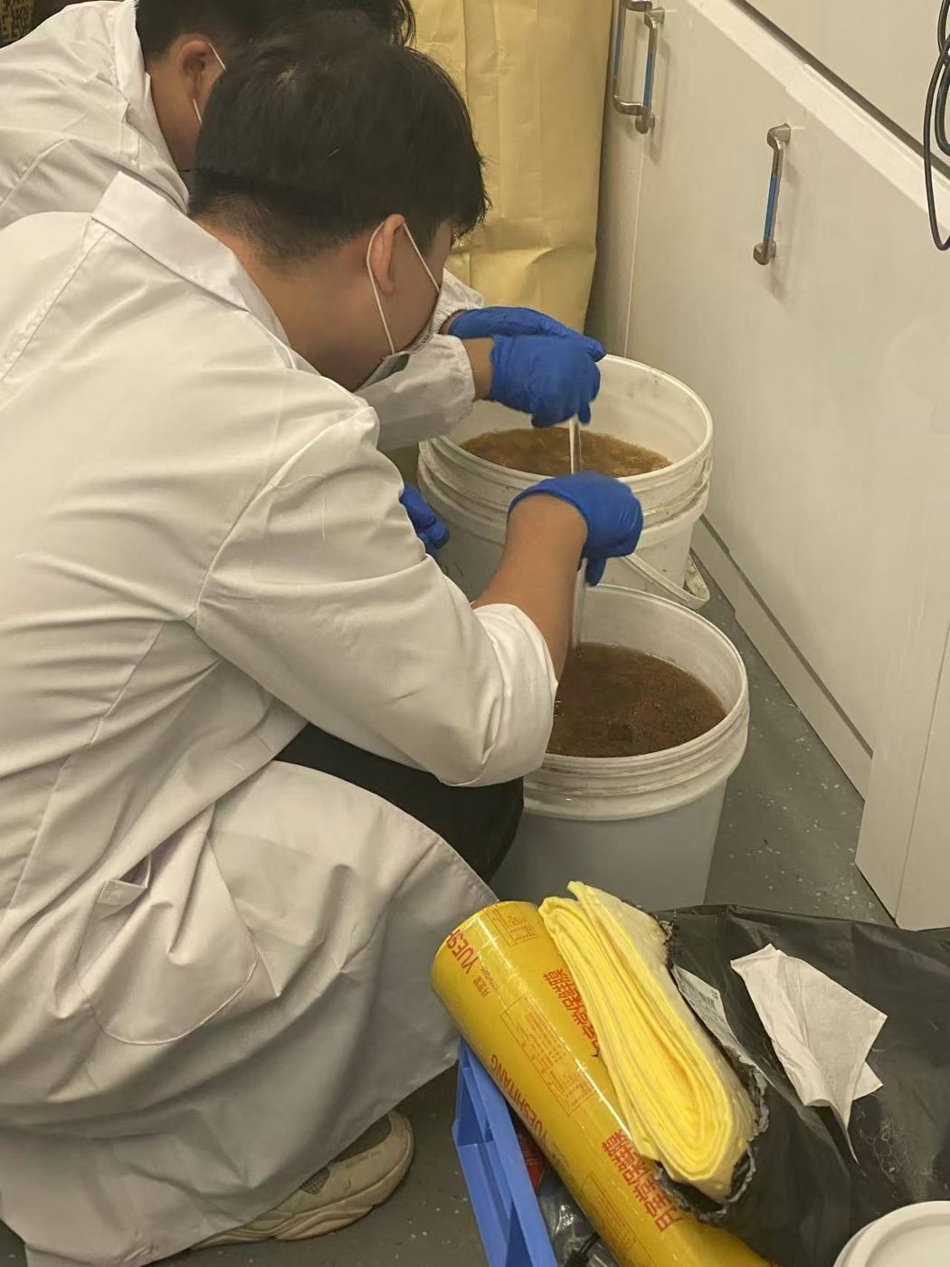 Laboratory staff mixing recycled material formulations for testing