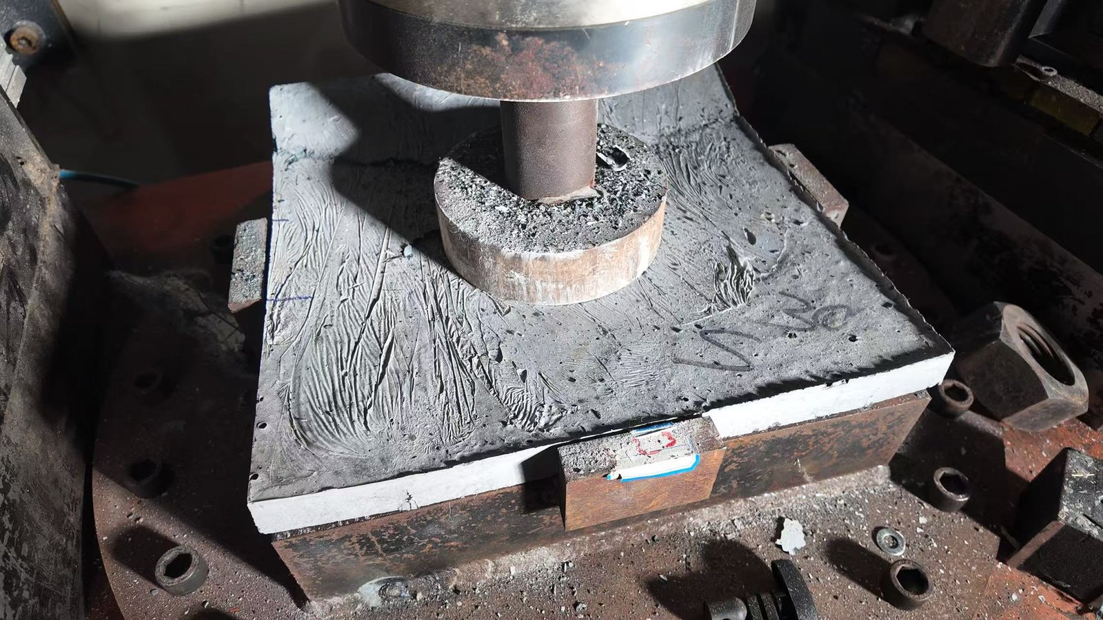 Testing head applying load to a cylindrical specimen